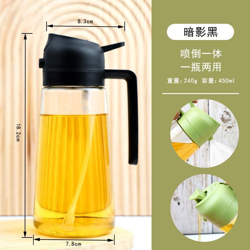 A transparent glass oil dispenser bottle with a black, dual-function (spray and pour) plastic lid and integrated handle, containing yellow cooking oil. It has dimensions of 18.2cm height and 7.8cm base diameter.
