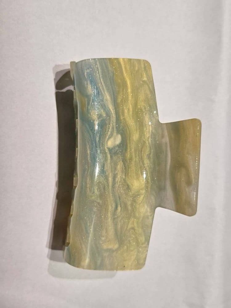 Marbled glitter hair claw clip with a blue, yellow, and white iridescent pattern