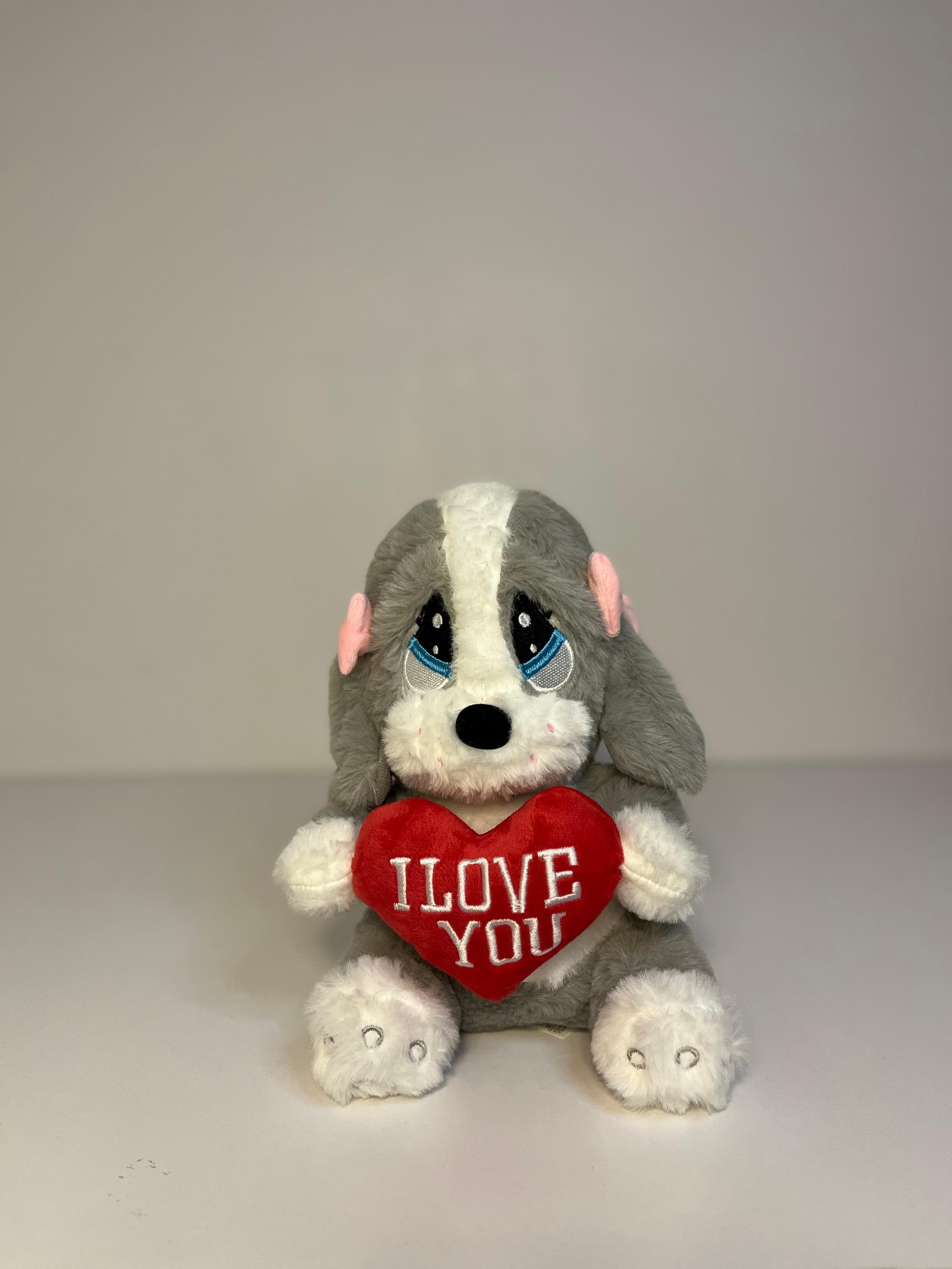 Plush dog stuffed animal with a sad expression, holding a red heart embroidered with 'I LOVE YOU'