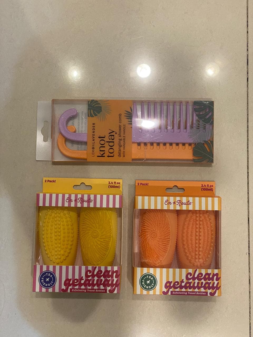 Lemon Lavender Knot Today detangling shower comb set with a hangable handle, featuring a wide-tooth purple comb and an orange hook/handle.